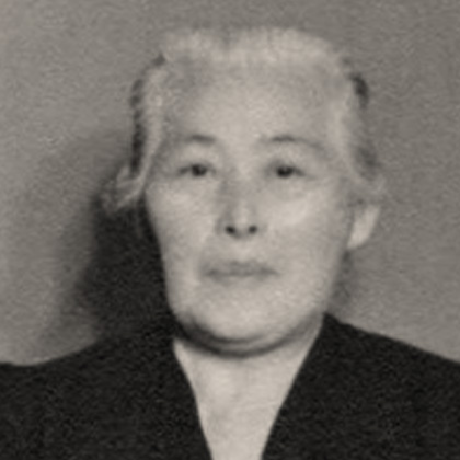 Ken Harada seated in a dark dress.