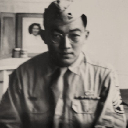 Harold Harada in US Army uniform, sitting on his bed in his barracks.