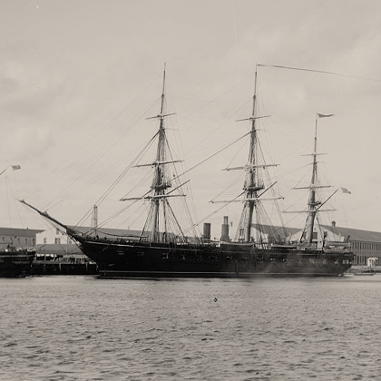 U.S.S. Pensacola, a wooden steam sloop-of-war ship, on the water with another ship visible behind.