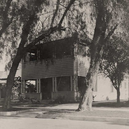 The Harada House flanked by two trees with an open second floor sleeping porch.